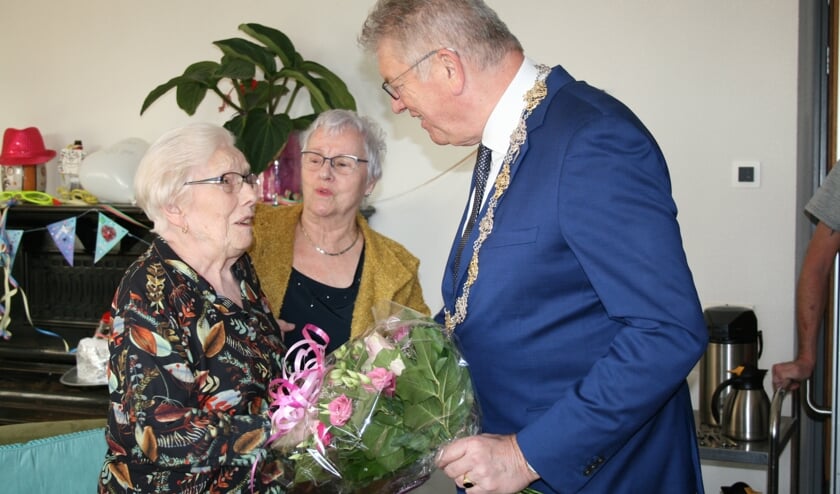 Honderdjarige mevrouw Corrie van Broekhoven wordt door burgemeester Frank Petter gefeliciteerd.