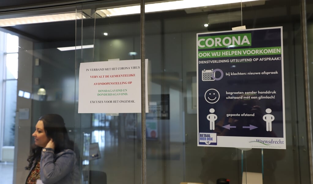 Informatie over corona-maatregelen aan de balie in het gemeentehuis van Woensdrecht 