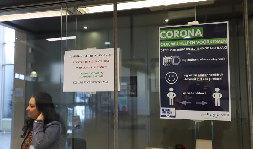 Informatie over corona-maatregelen aan de balie in het gemeentehuis van Woensdrecht