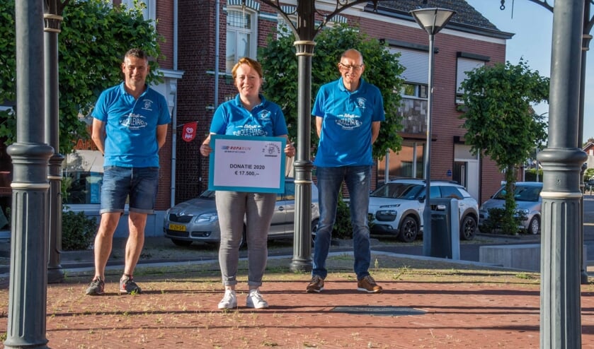 Teamcoördinator Elly-May van Ginneken presenteert de cheque voor de Stichting Roparun, met teamleden Marcello Hoezen en Jules Theuns.