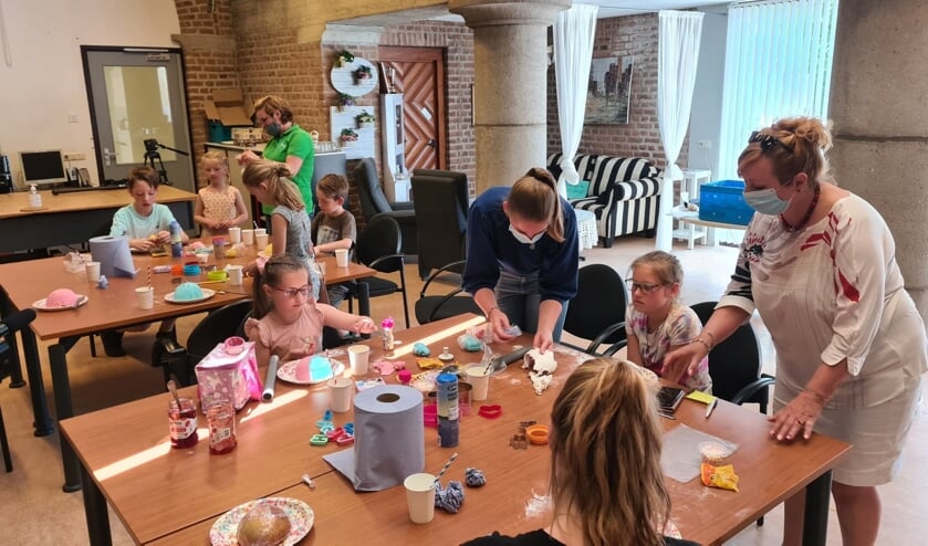 <p>Jonge mantelzorgers vermaken zich met taartjes versieren.</p>