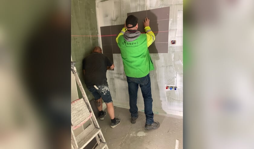 Bewoner Bob betegelt zijn eigen badkamer.