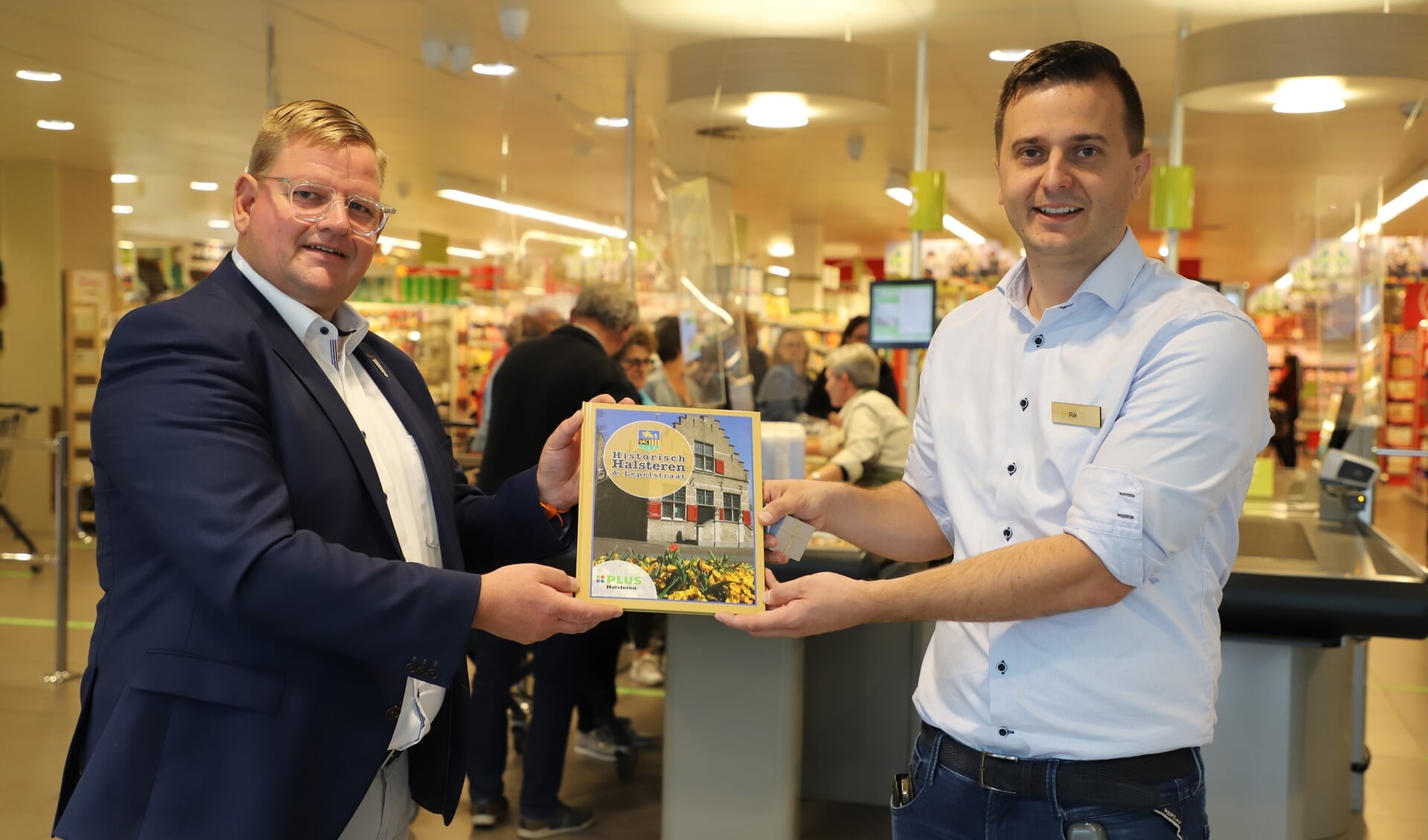 Wethouder Patrick van der Velden krijgt uit handen van Rik Linssen het eerste exemplaar aangeboden van Historisch Halsteren & Lepelstraat.