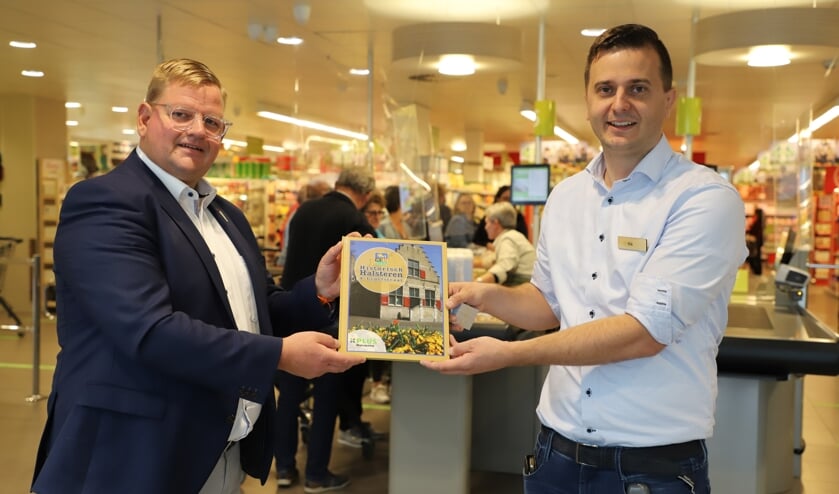 <p>Wethouder Patrick van der Velden krijgt uit handen van Rik Linssen het eerste exemplaar aangeboden van Historisch Halsteren & Lepelstraat.</p>