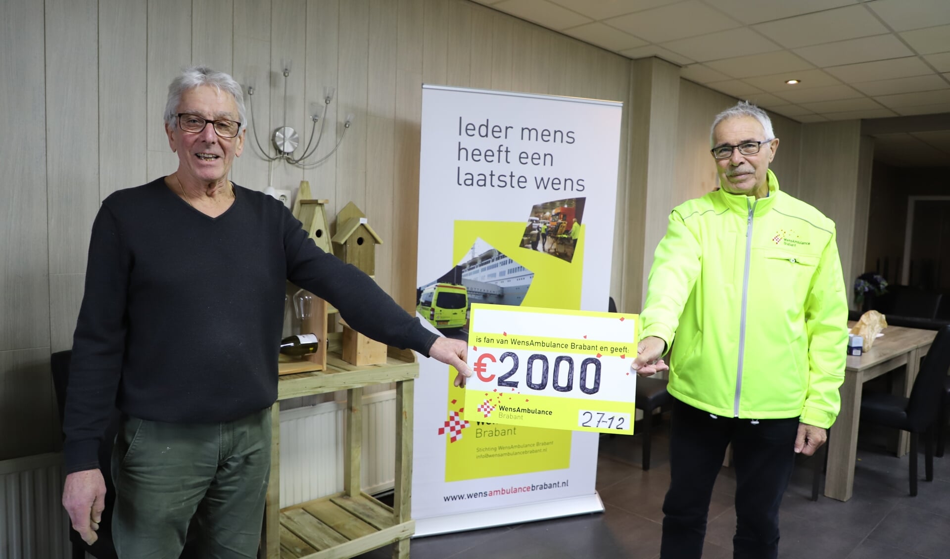 Piet Groffen overhandigt de cheque aan Peter Bogers van WensAmbulance Brabant.