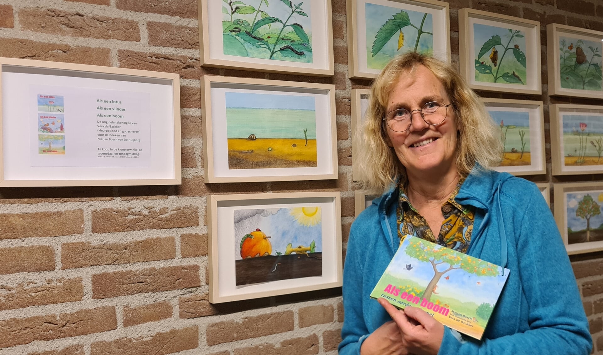 Marjan Bosch met haar kinderboek voor de originele illustraties die te zien zijn in het Broederhuis. 