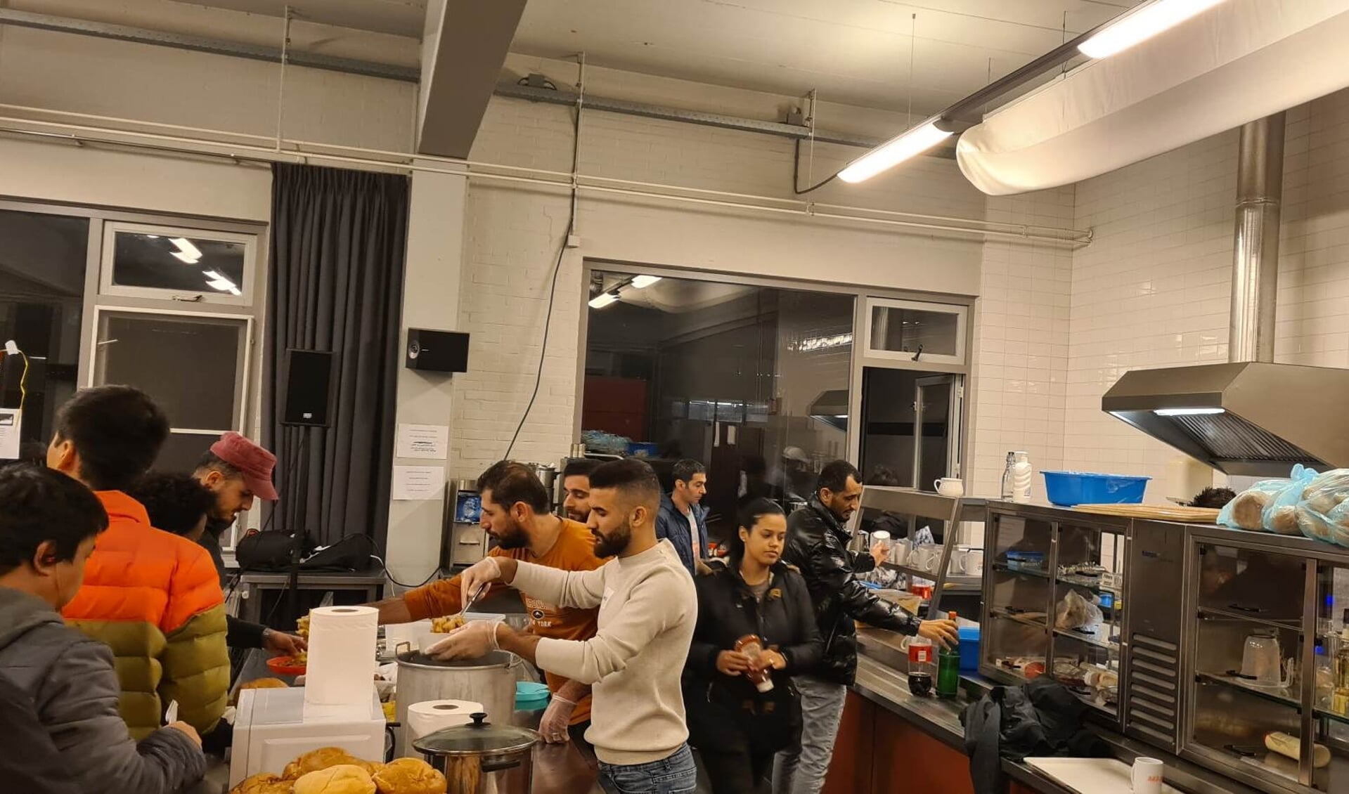 Vluchtelingen in Putte bereiden zelf hun maaltijden in de keuken van het bedrijfspand. 