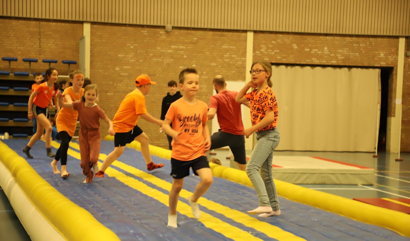 Kinderen van basisschool De Rode Schouw leven zich bij de Koningsspelen uit in sporthal de Kannebuis. 