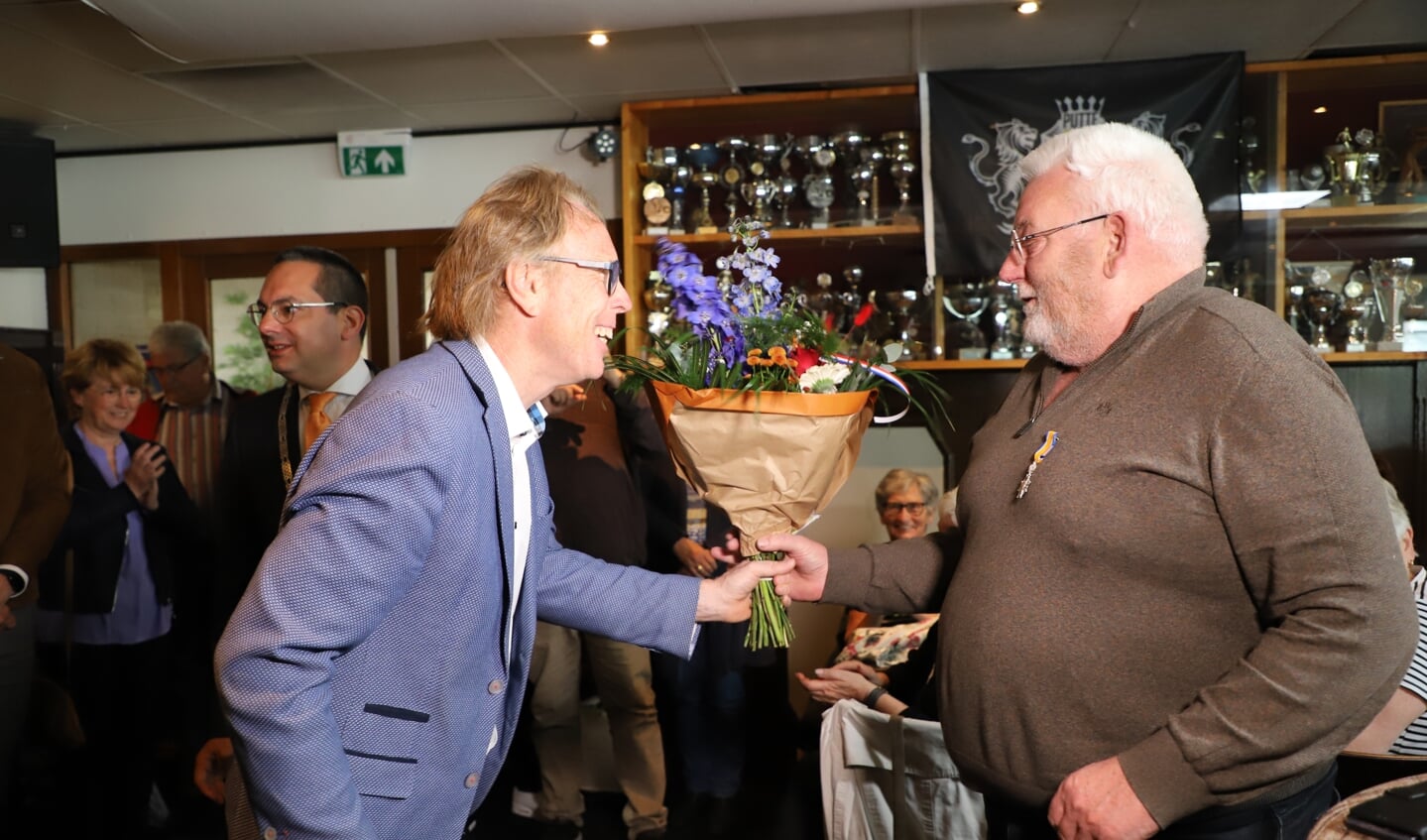 Onderscheiden Wout den Daas ontvangt bloemen van wethouder Lars van der Beek.