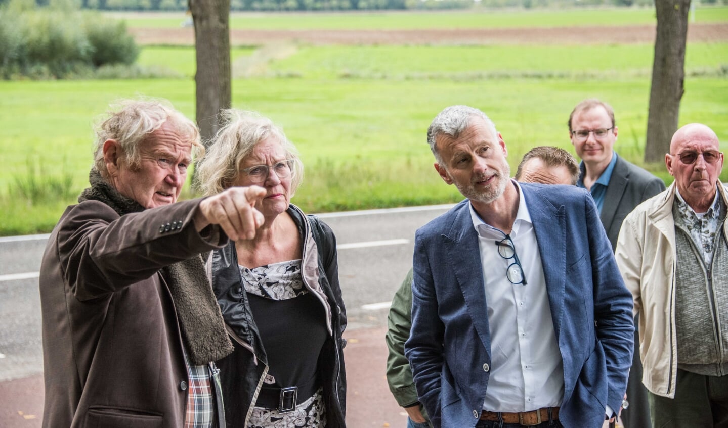 Ruud Pommée toont wethouders Demmers, Verroen en Pals waar de geplande hoogbouw komt te staan ten opzichte van zijn tuin.