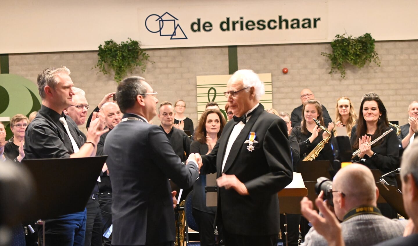 Dirigent Arnold Wensink wordt geridderd bij het afscheidsconcert van muziekvereniging De Hoop. 