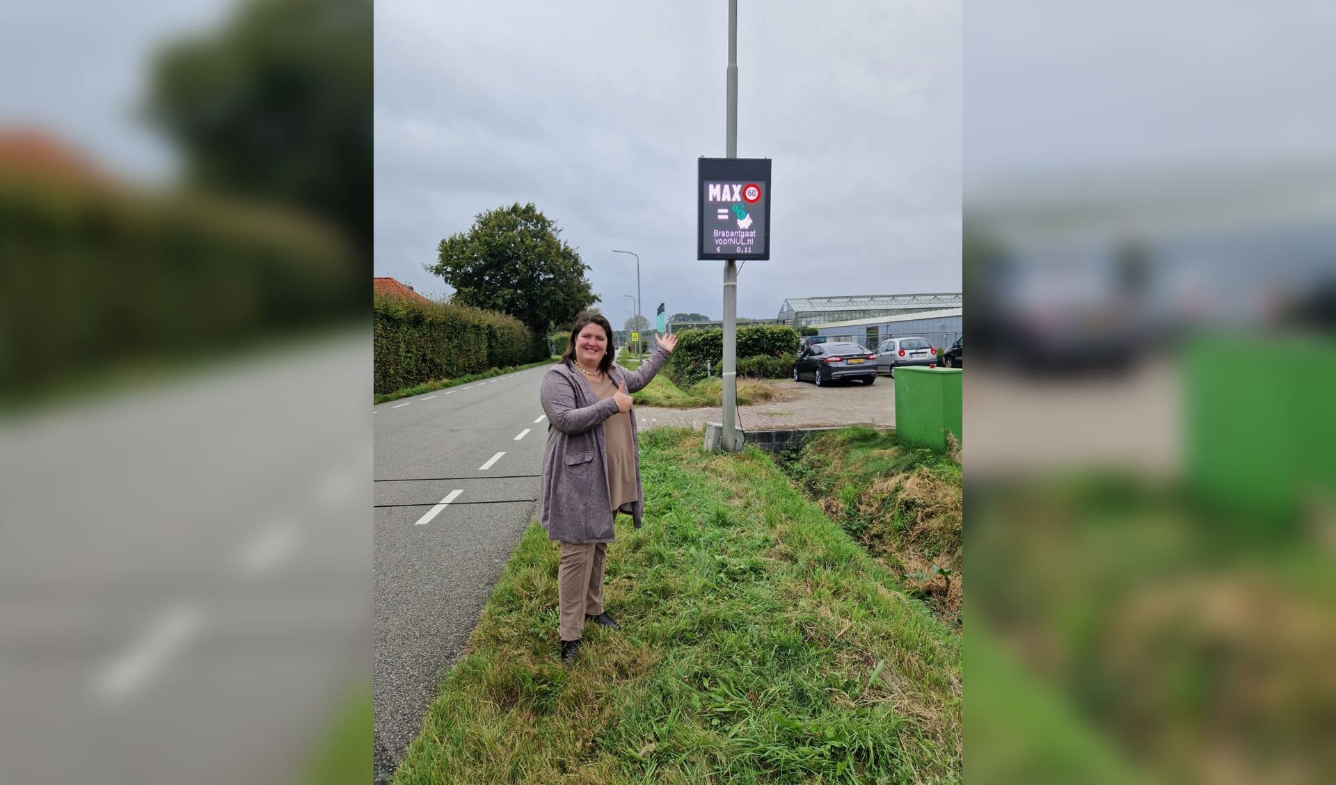 Wethouder Vermeulen toont de snelheidsmeter langs de Essenseweg in Nispen.