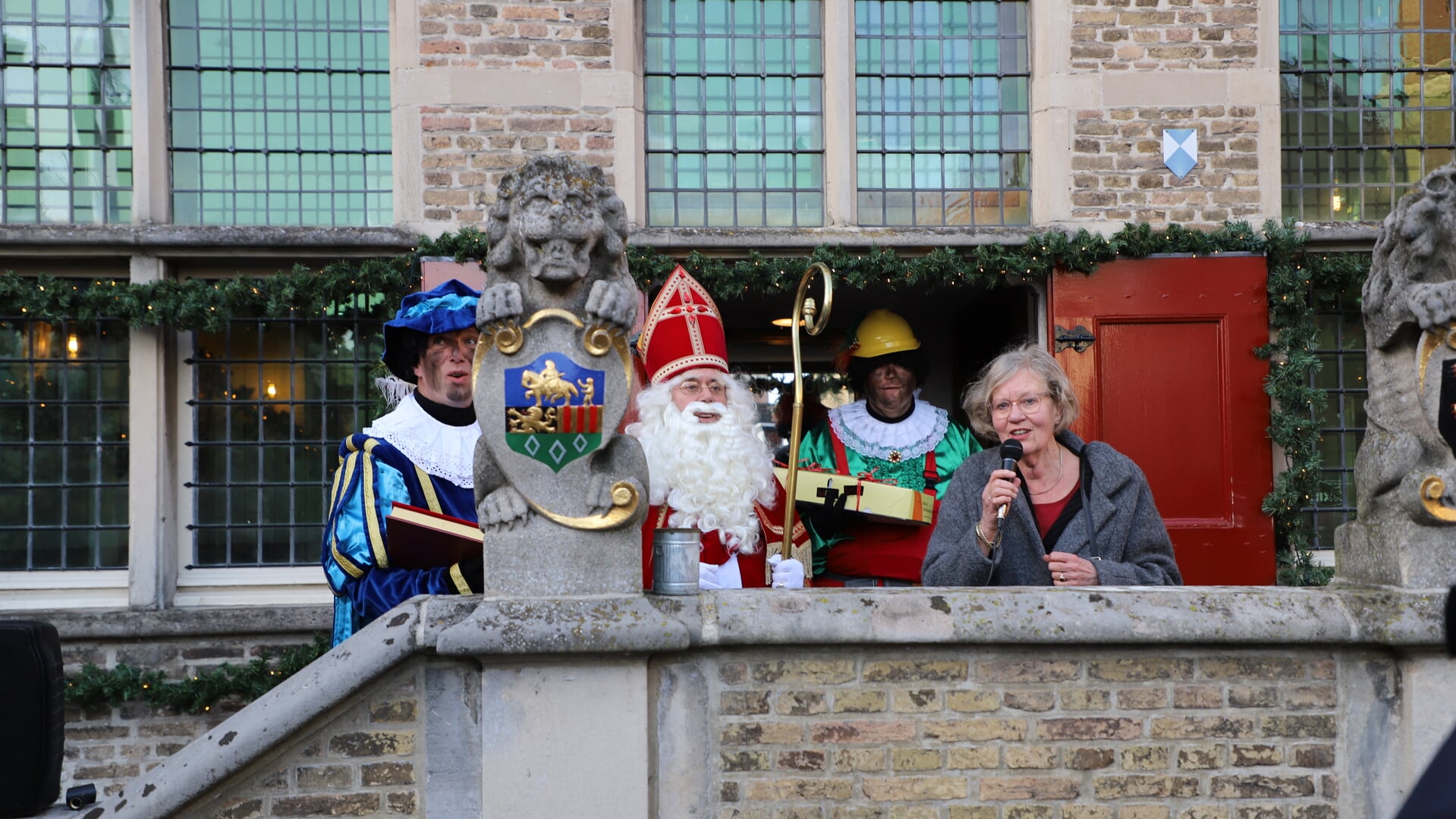 Sint Nicolaas wordt hartelijk verwelkomd door wethouder Letty Demmers bij het oude raadhuis.