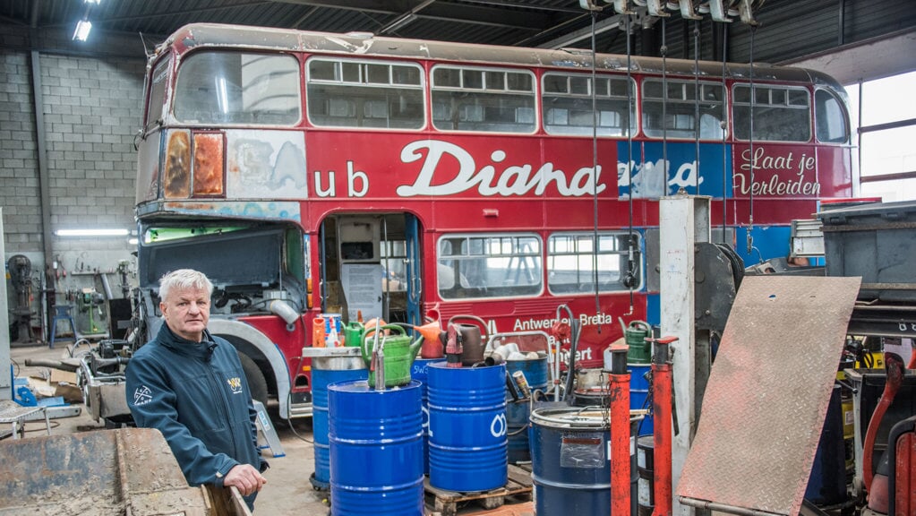 Kees Kuijlen in de werkplaats waar de flink beschadigde dubbeldekker van wielerploeg Sauna Diana.