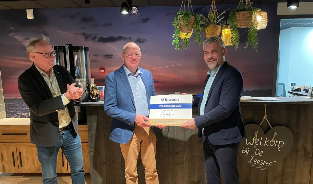 Veilingmeester Martijn Meerman (rechts) overhandigt de cheque van € 7.944,- aan Piet Derks, Gouverneur landelijk bestuur (midden) en Aart de Zeeuw, Luitenant Gouverneur Zeeland (links).