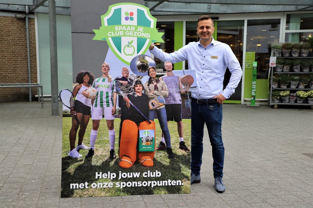 Rik Linssen van PLUS Halsteren met het promotiebord van de sponsorpuntenactie voor plaatselijke verenigingen.
