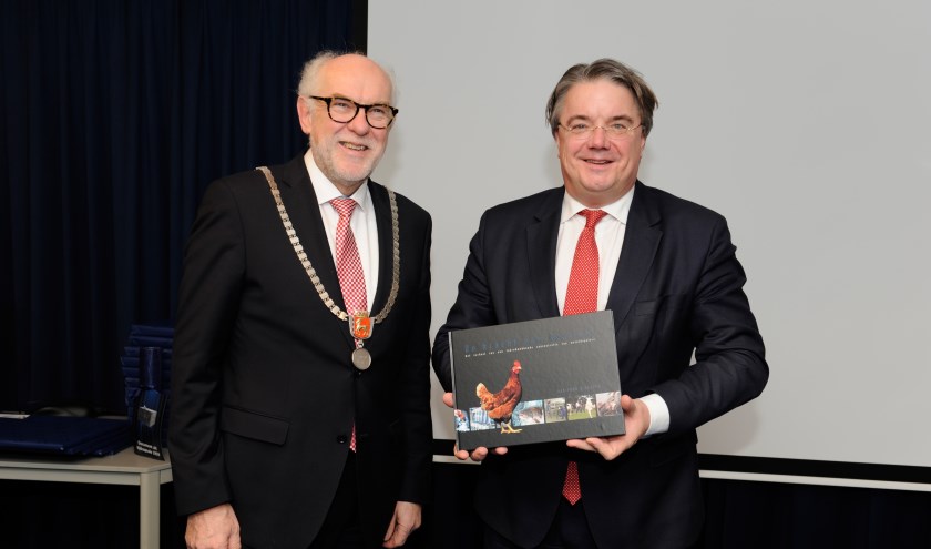 Het eerste exemplaar van 'De kracht van Boxmeer' werd door burgemeester Karel van Soest gegeven aan Wim van de Donk. (foto: Ingrid Driessen)