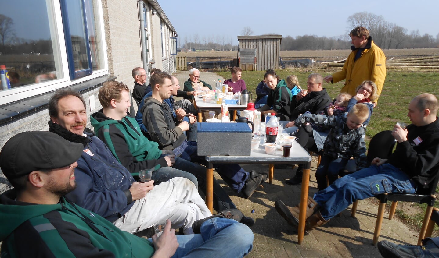 De vrijwilligers van Scouting Veghel genieten tussen het harde werken door in het zonnetje van een lunch.