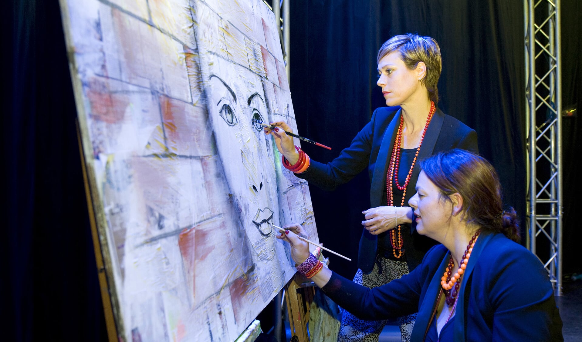 Karin en Simone in De Pul bezig met een schilderij op krantenpapier (foto: Ad van de Graaf)
