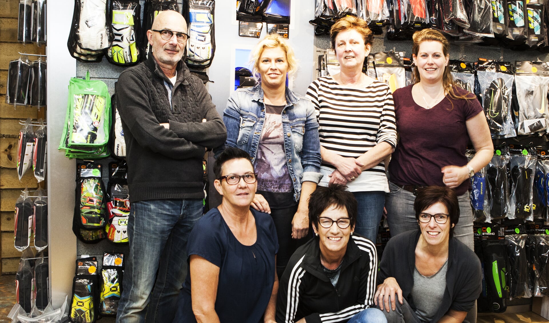 Eric van Tits (links) en zijn partner Nellie (midden-onder) tussen enkele medewerkers van de Sinttunnisse schoenenzaak die begin volgend jaar sluit. Foto: Diana Derks