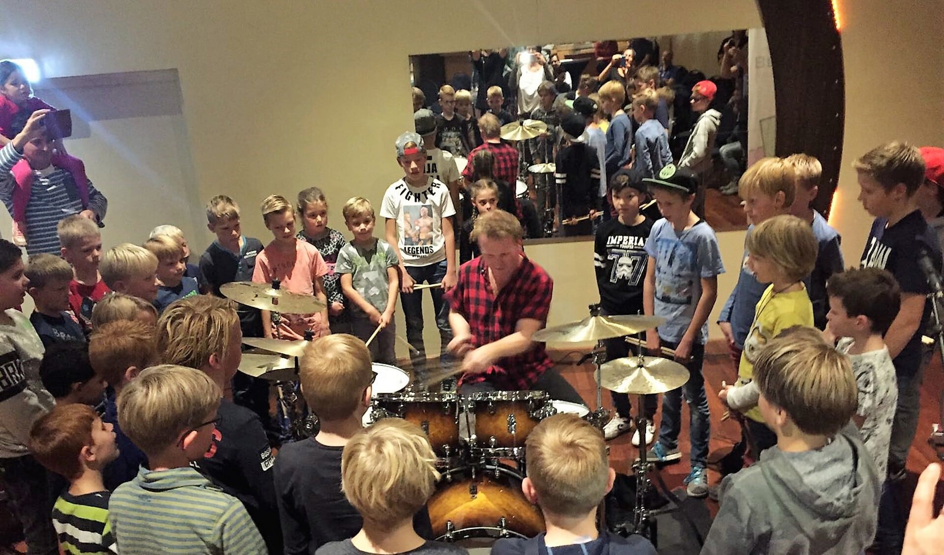 De jeugd verdringt zich rondom drummer Olaf Fase tijdens een eerdere workshop. 