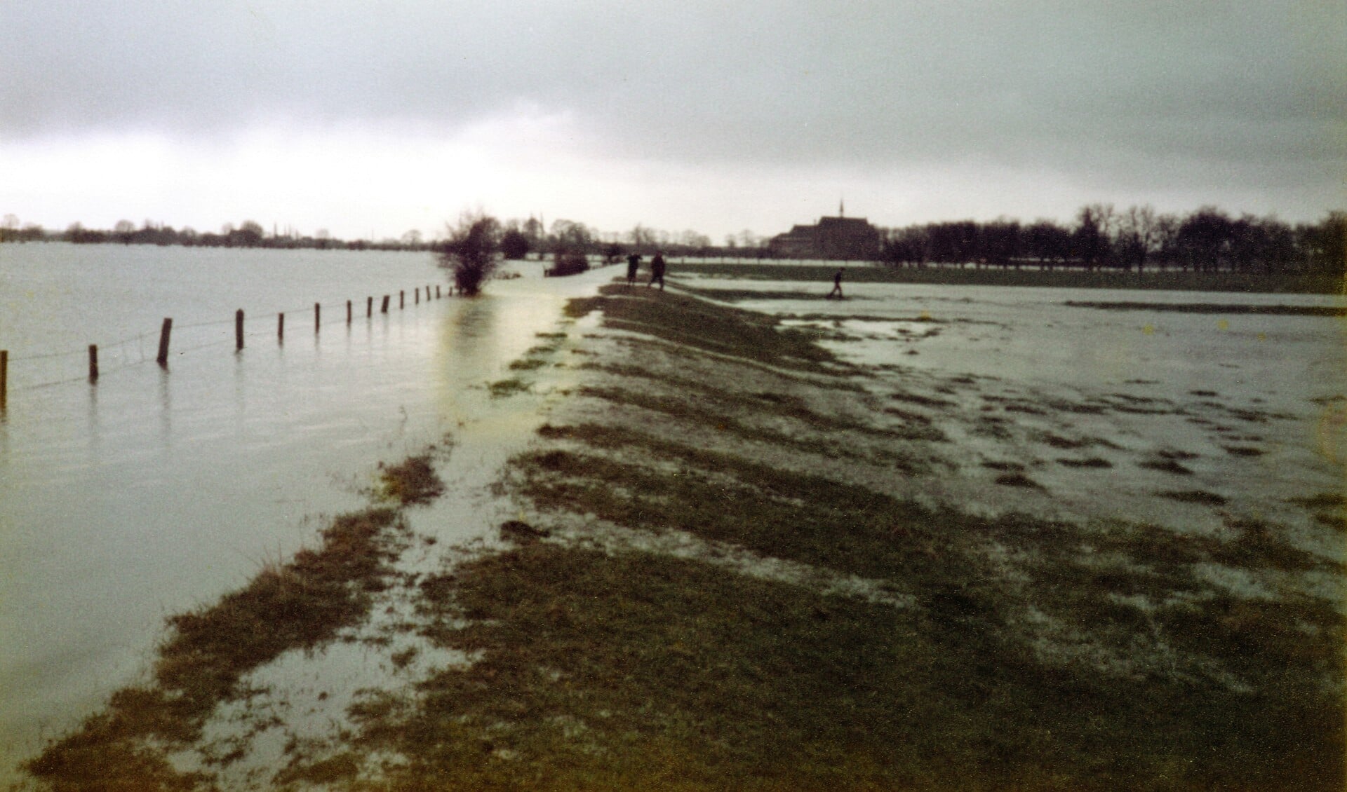 De Gèèstendiek oostelijk van Middelaar in 1984. Onherkenbaar lopen Leen en Jan Teunissen en Joop Verweij op de dijk. Op de achtergrond het klooster van Sint Agatha. Foto: Gerd Lamers, bewerkt door Joop Janssen