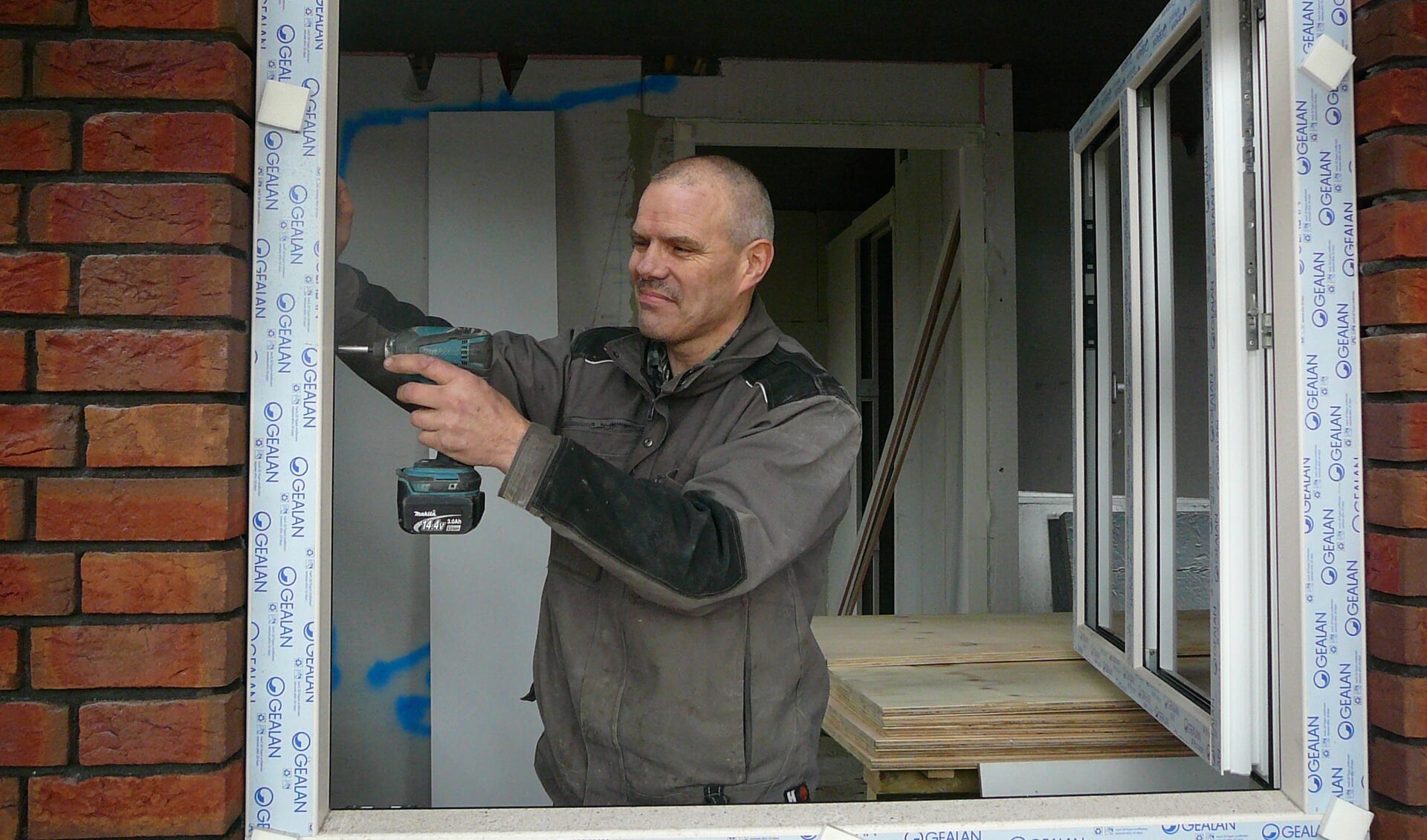Bert Cox staat plaatst alle ramen in het in aanbouw zijnde Thomashuis in Gennep. (foto: Dorry Smeets)