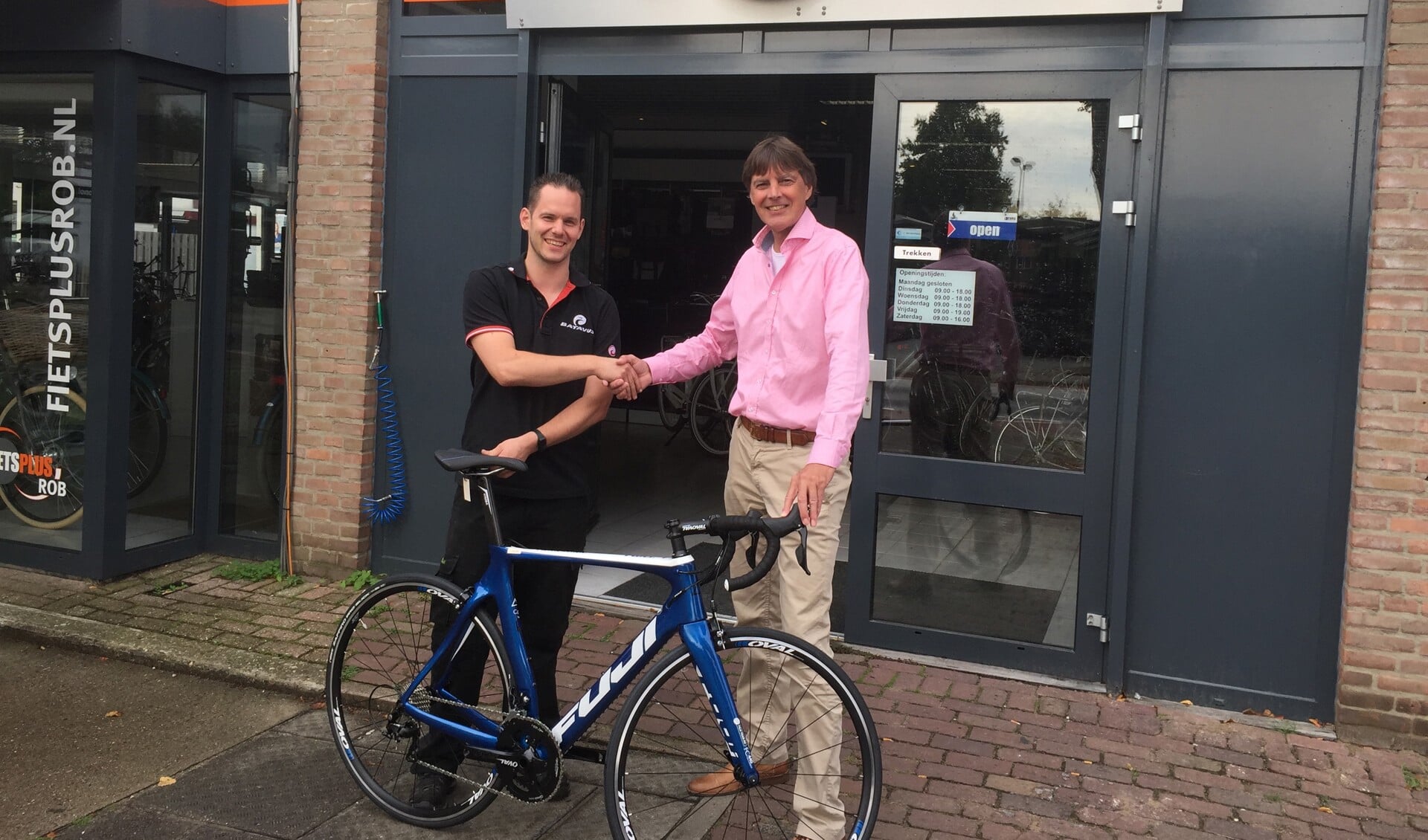 Wim Melsen (rechts) neemt de fiets in ontvangst van Rob van Hulten, eigenaar van Fietsplus Rob. 