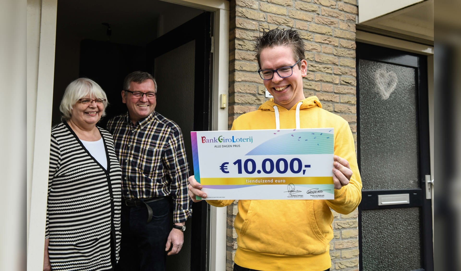 Gert Jan uit Geffen ontvangt, in het bijzijn van zijn ouders, een cheque van 10.000 euro van de BankGiro Loterij.