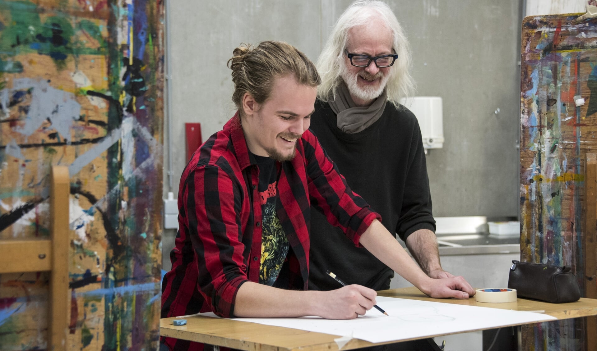 Docent Peter Linnartz en student Tim van Nielen zijn druk met de voorbereidingen voor een schilderij. 