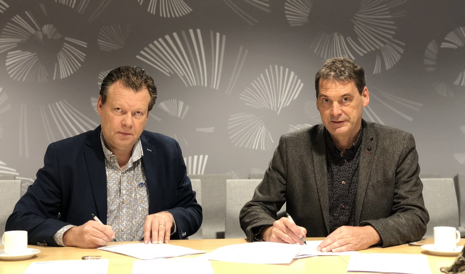 Eus Witlox en Jan van Vucht ondertekenen de contracten. 