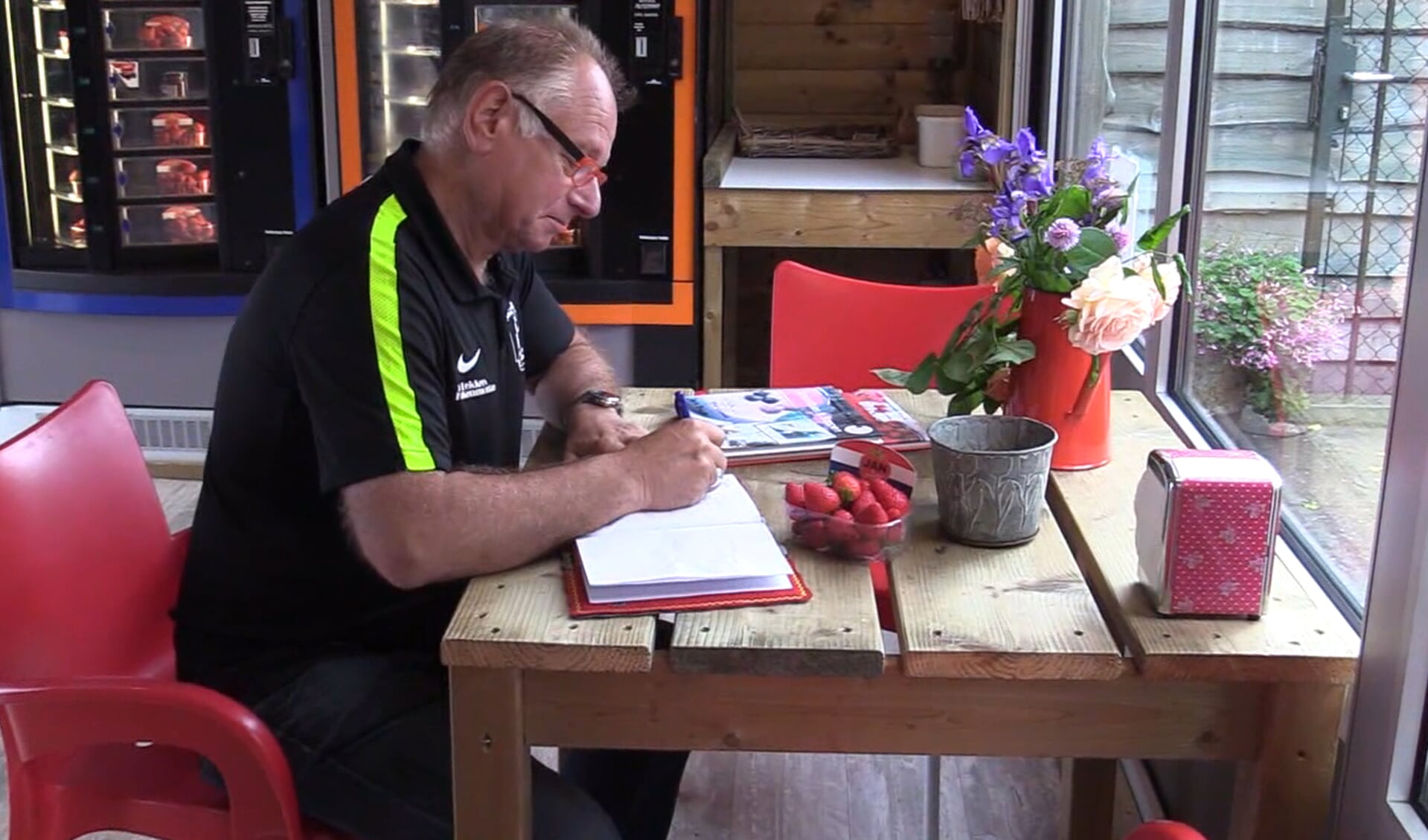 Giel van Orsouw tekent het gastenboek bij de voorzitter van FC De Rakt.