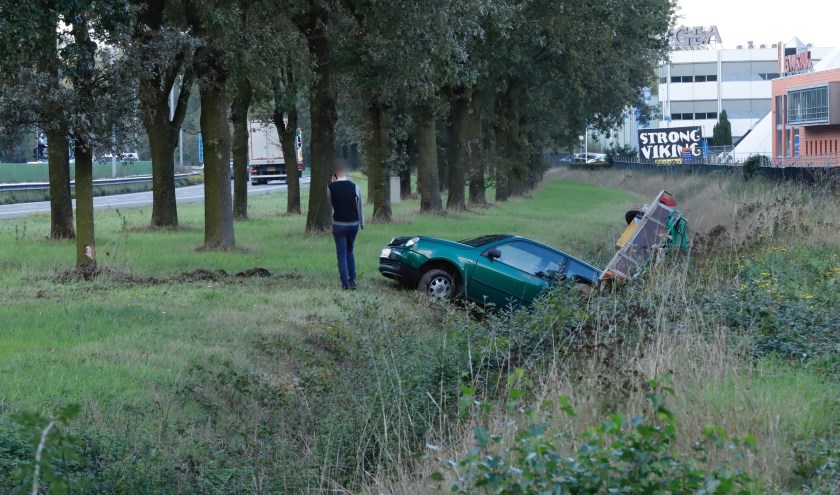 Auto en aanhanger belanden naast de A73 bij Cuijk.