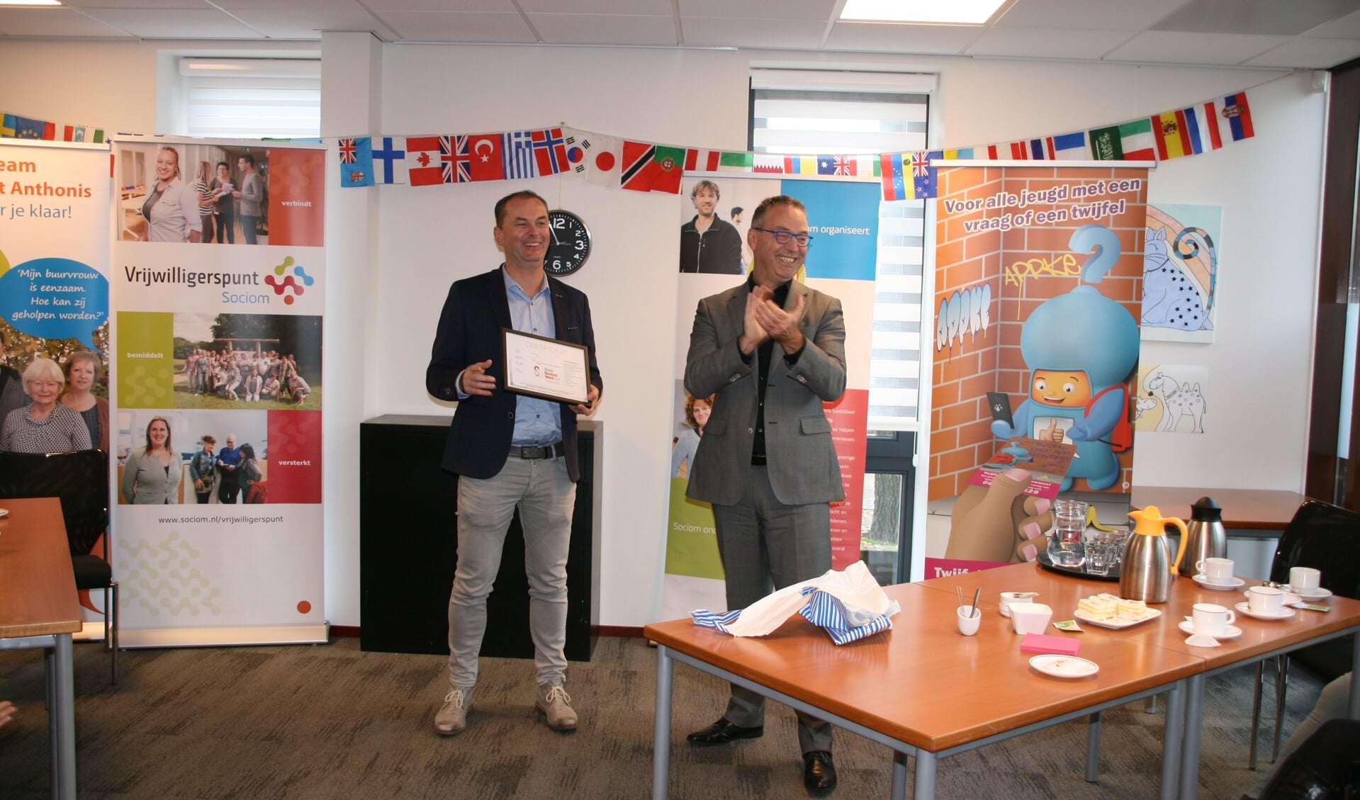 Roland van der Heijden (links) van Sociom ontving uit handen van Lex Staal van Sociaal Werk Nederland het Kwaliteitslabel Sociaal Werk.
