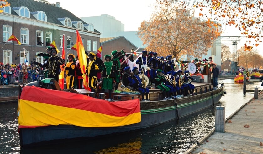 De boot van Sinterklaas wordt begeleid door een kleine vloot van vier schepen, waarop allerlei soorten pieten staan.