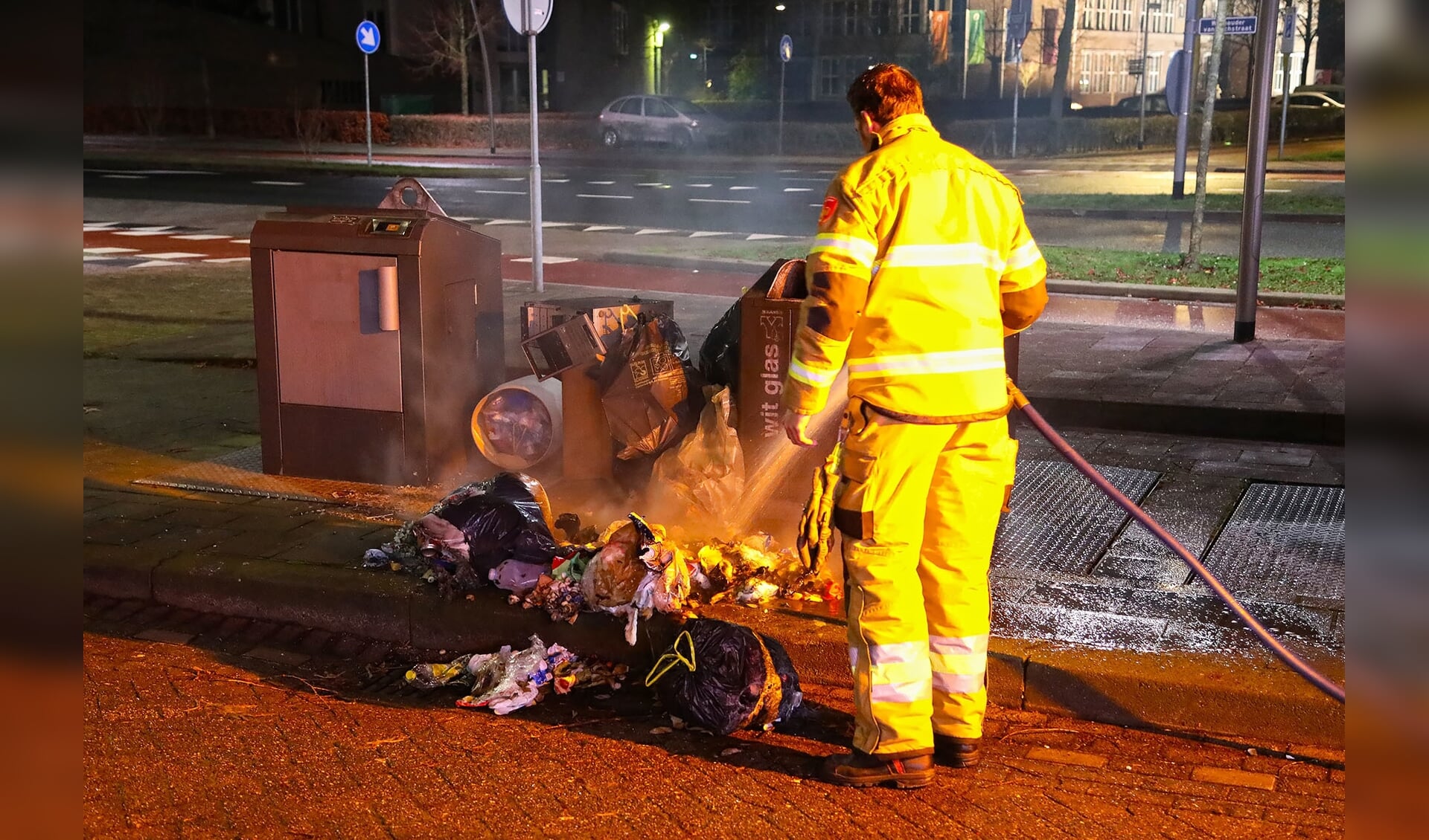 Brandweer blust afval bij ondergrondse afvalcontainer. (Foto: Gabor Heeres / Foto Mallo)