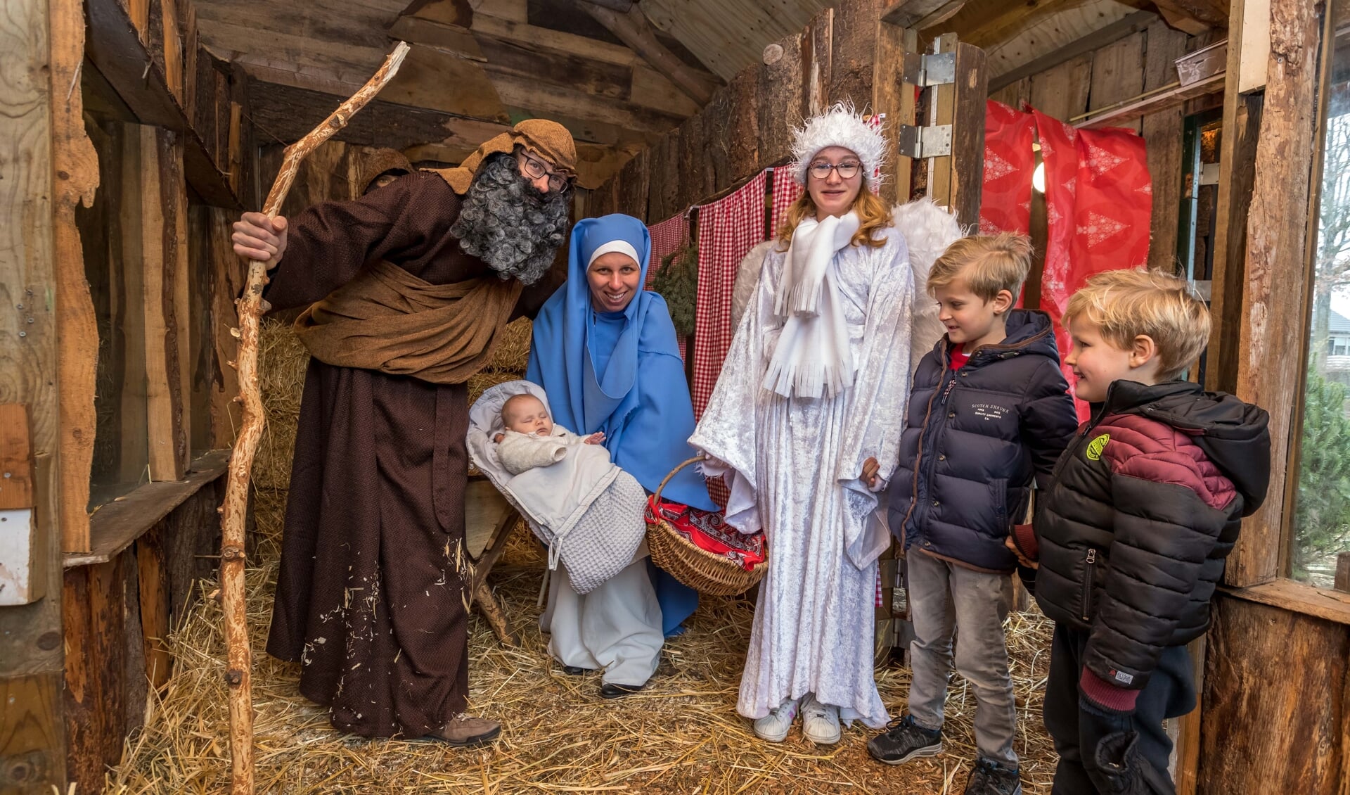 Jozef, Maria, het kindeke Jezus, een engel en een paar bezoekers.