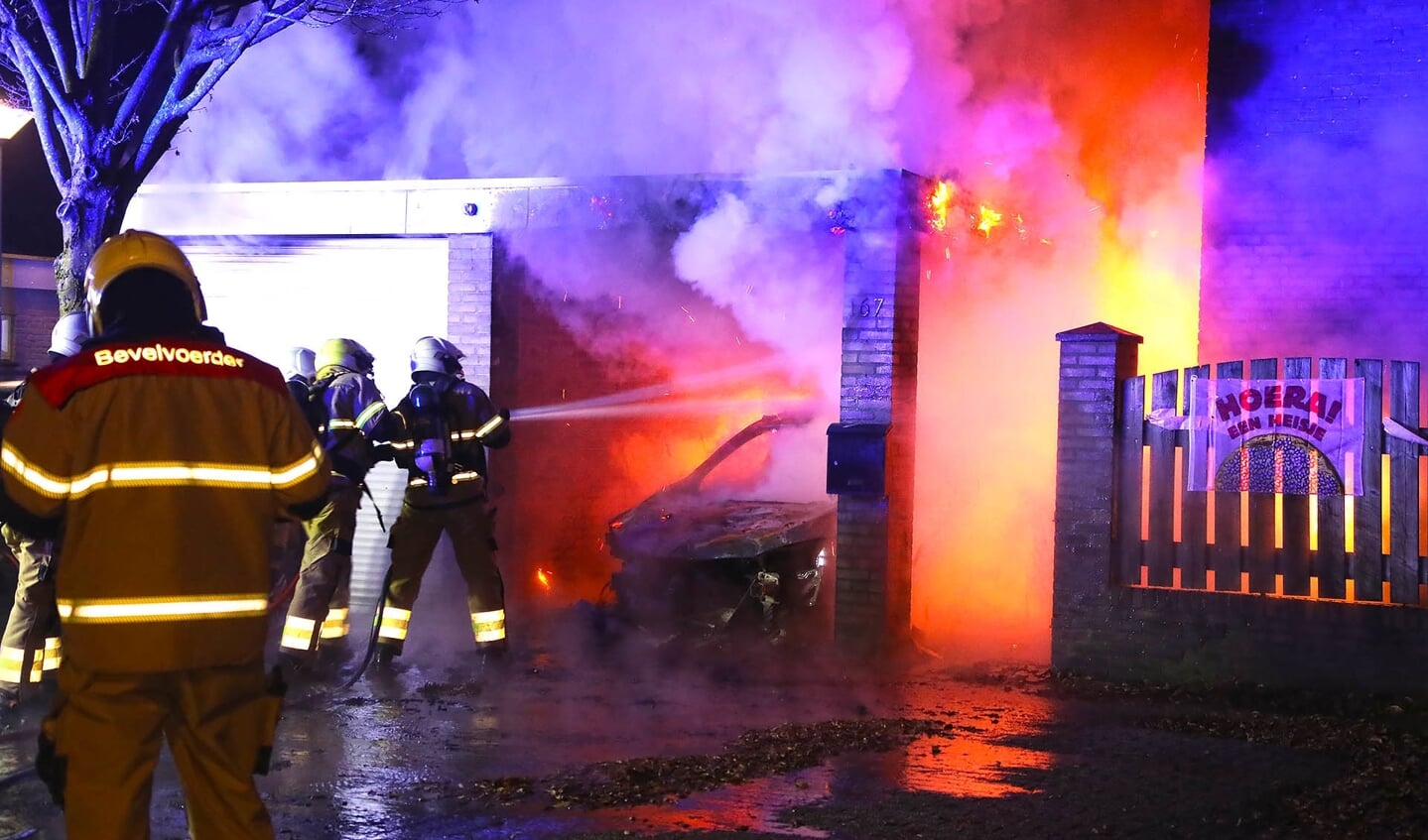 Autobrand slaat over op woning; jong gezin weet op tijd te vluchten. (Foto: Gabor Heeres / Foto Mallo)