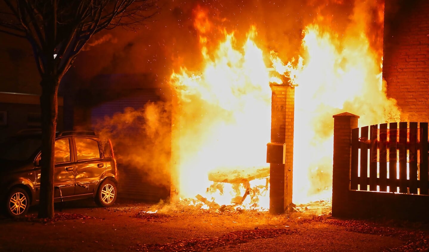 Autobrand slaat over op woning; jong gezin weet op tijd te vluchten. (Foto: Gabor Heeres / Foto Mallo)