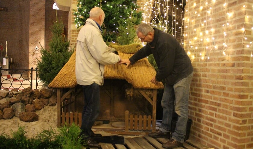 Jack Linders (links) en Toon Gerrits. Samen met de andere vrijwilligers van de parochie zorgen ze ervoor dat de kerststal er weer mooi uitziet voor het publiek.