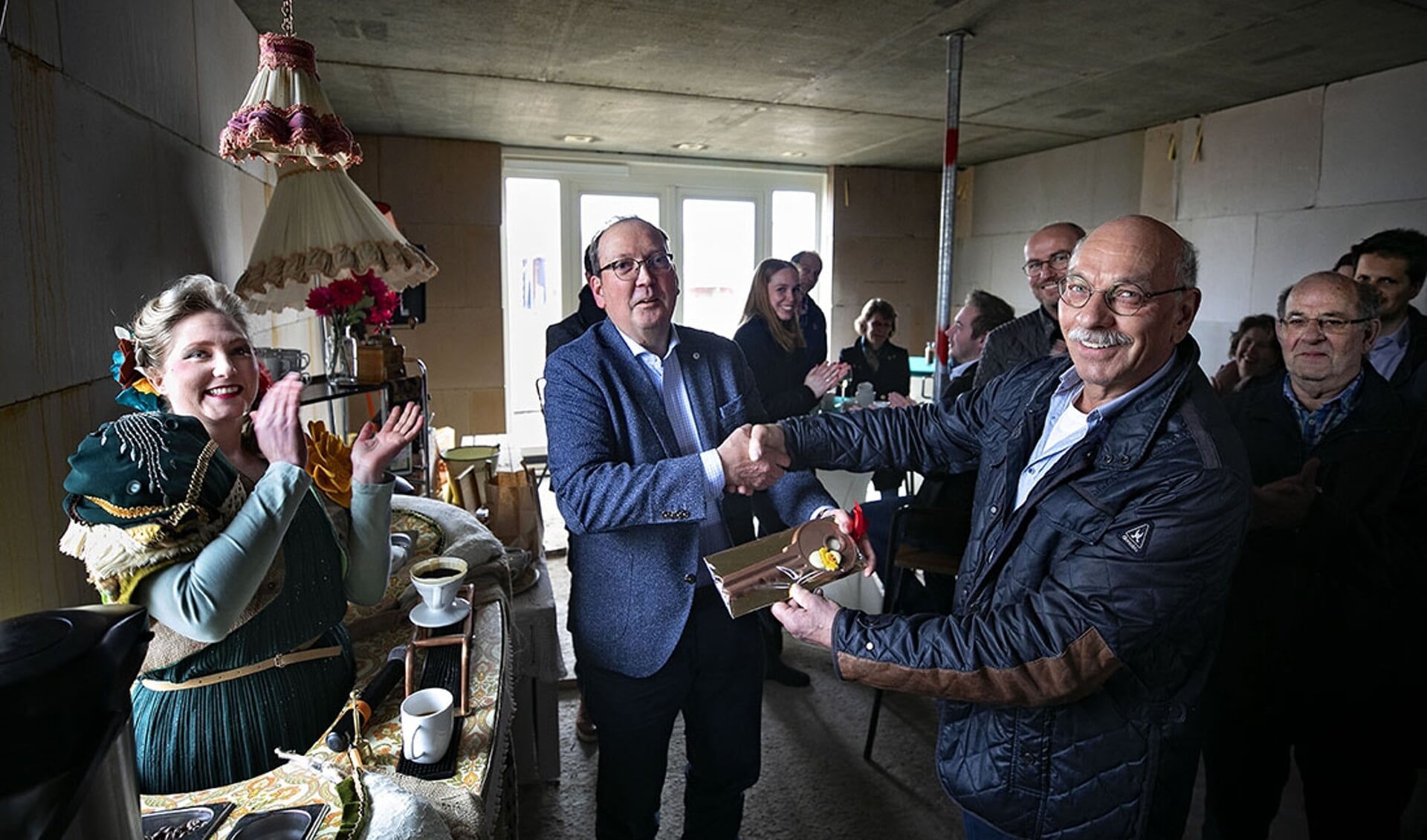 Wethouder Van den Bogaard (L) overhandigt aan een toekomstige bewoner de 'huissleutel'. 