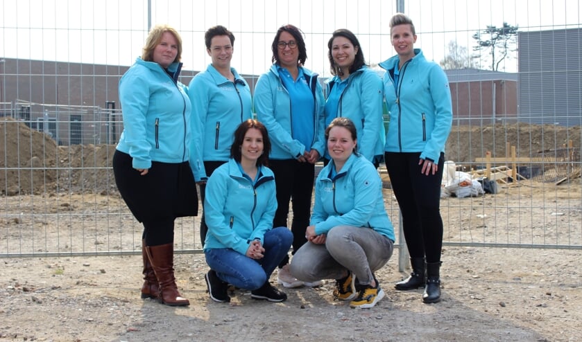 Medewerkers van Eerste Klas poseren voor de bouwplaats.