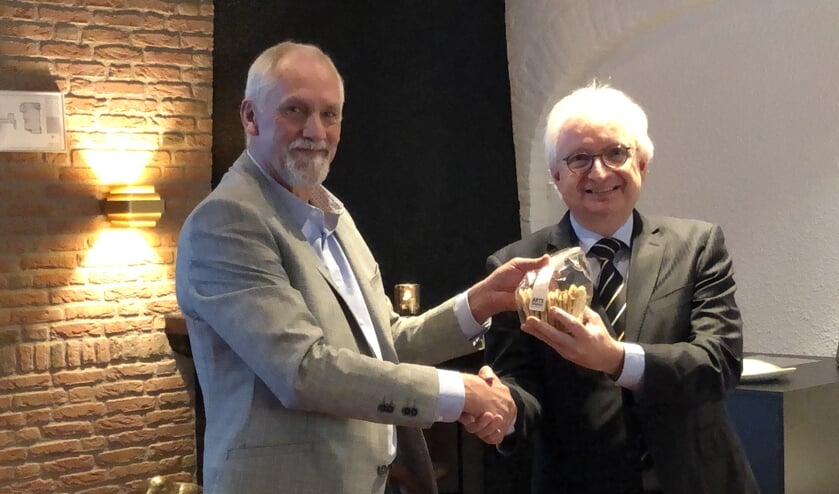 Theo van Brunschot (links) overhandigt burgemeester Gradisen het eerste pakje Moockse Raampjes. (foto: Jos Gröniger)