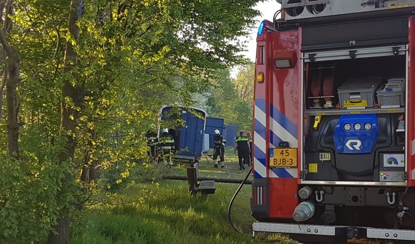 De brandweer blust de brand in de keet