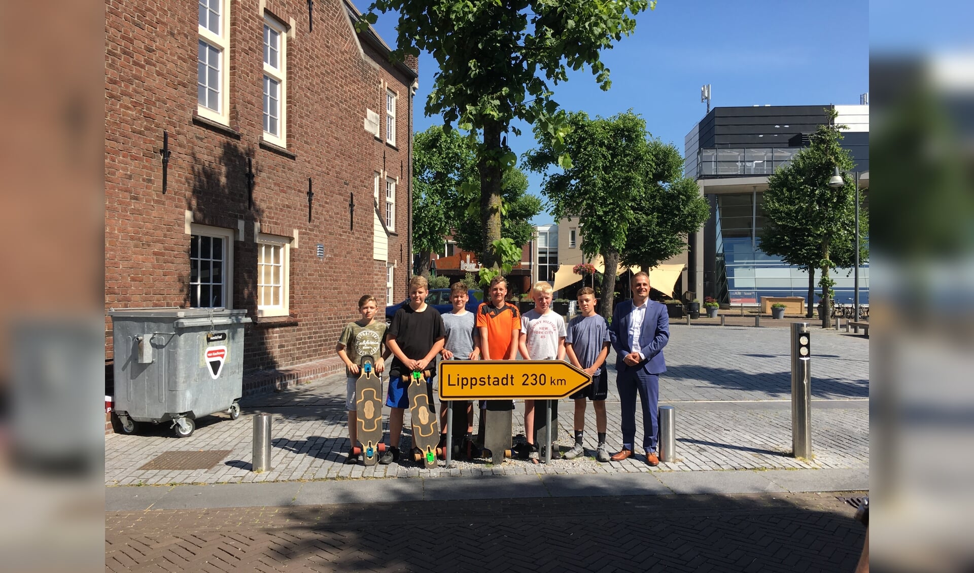 De jongens na hun aankomst in Uden, samen met wethouder Gijs van Heeswijk.