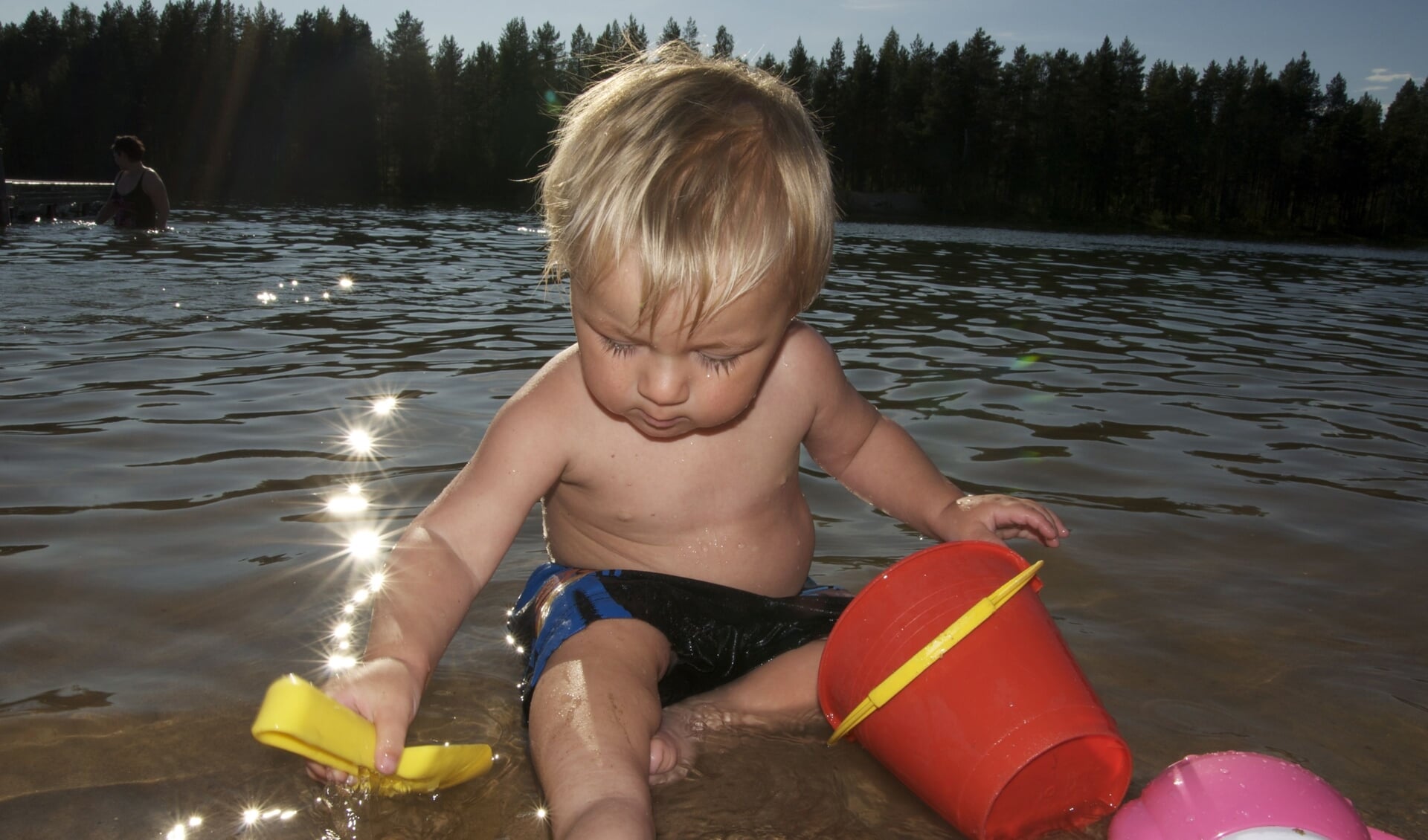 Dit jongetje geniet van de zon en van het water.