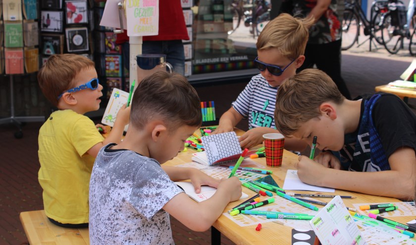 De kinderen werden niet gehinderd door het warme weer en deden hun best bij de kleurwedstrijd bij Schellen Boek- en kantoorboekhandel.