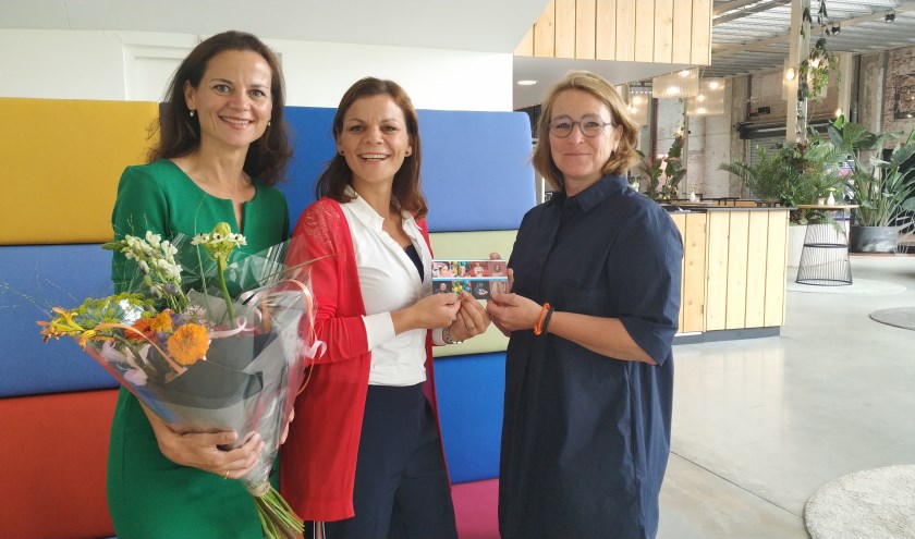 Diana van Huijgevoort van De Blauwe Kei overhandigt de prijs aan mevrouw Greenall en haar zus.