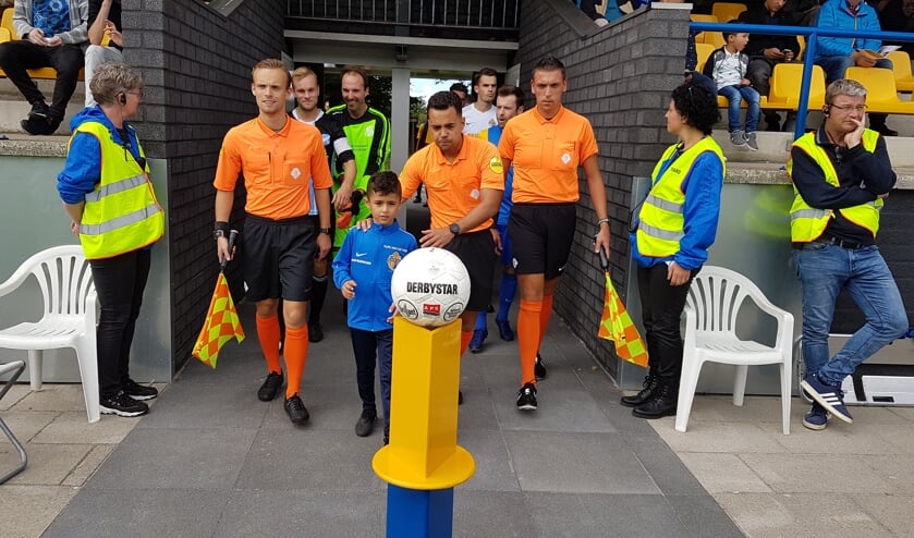 De opkomst van de teams met het arbitrale trio