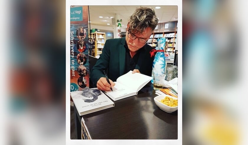 Bas Geeraets signeert zijn boek.